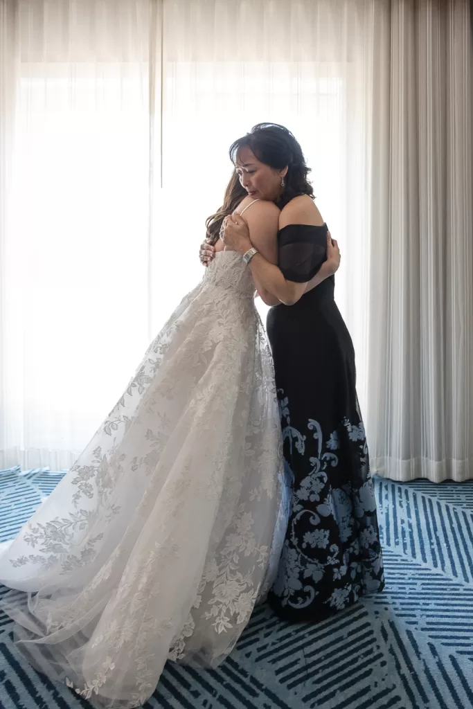 mother of the bride and bride hugging full length photo